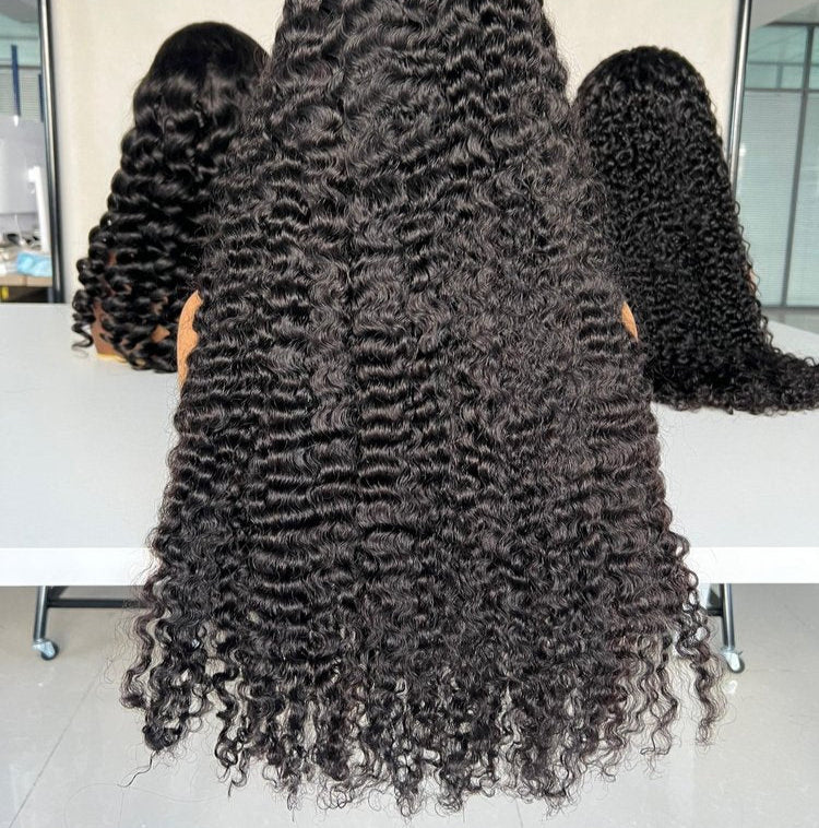 Person with long, curly hair sitting in a chair with mirrors on either side.
