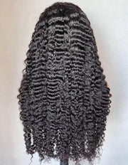 Black curly wig on a mannequin head against a plain background